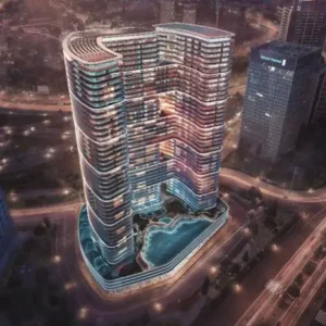 Aerial night view of curved twin-tower complex with pool amenity